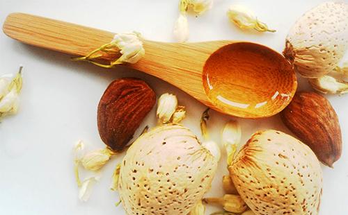 Цветы, орехи и золотое масло в деревянной ложке